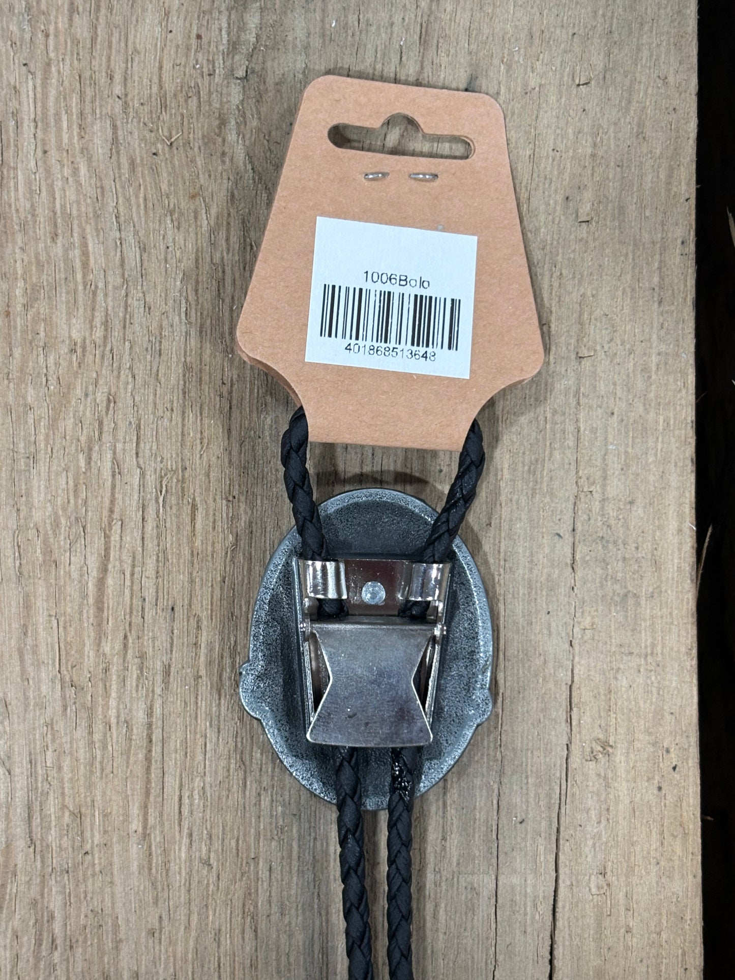 Metal clip with black cord on a cardboard backing with a barcode on a wooden surface