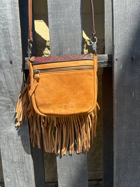 This Brown tooled leather and fringe crossbody bag has a removable and adjustable strap. Rear view showing zippered closure on outside pocket.