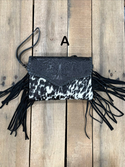 Black tooled leather and cowhide bag with side fringe. This bag has both a wristlet and should strap. Front View