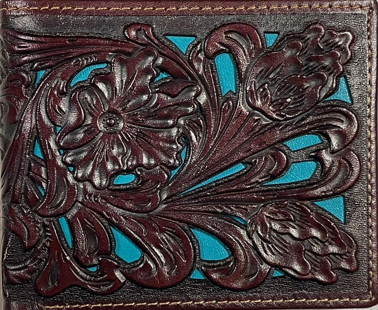 Close up of a Decorative leather wallet with intricate floral patterns on a turquoise background