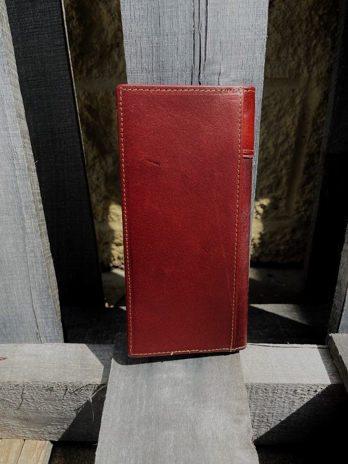 Brown leather wallet on a textured surface with a blurred background