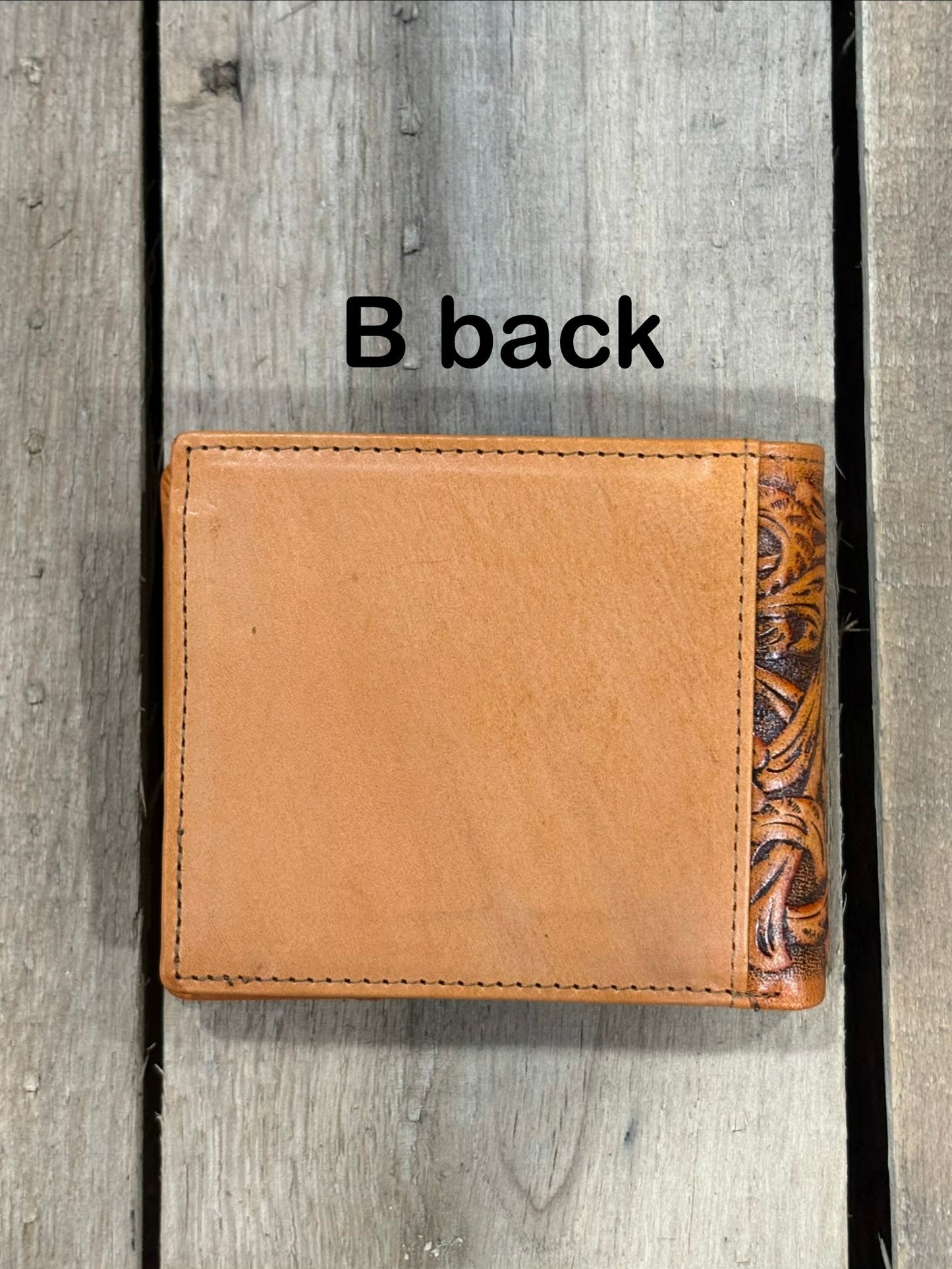 Light Brown leather wallet with floral patterns on a wooden surface