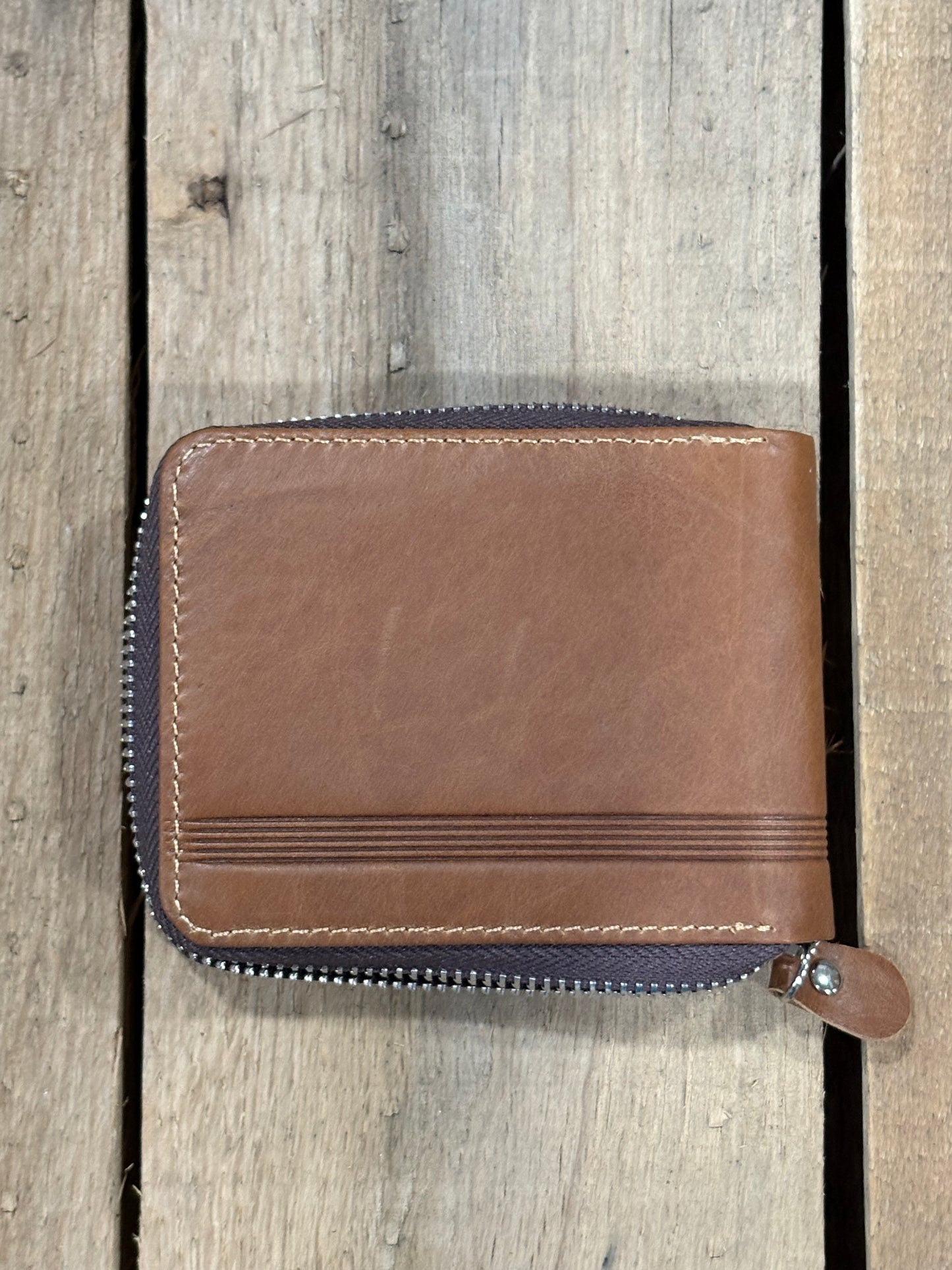 Brown leather wallet with zipper on a wooden surface