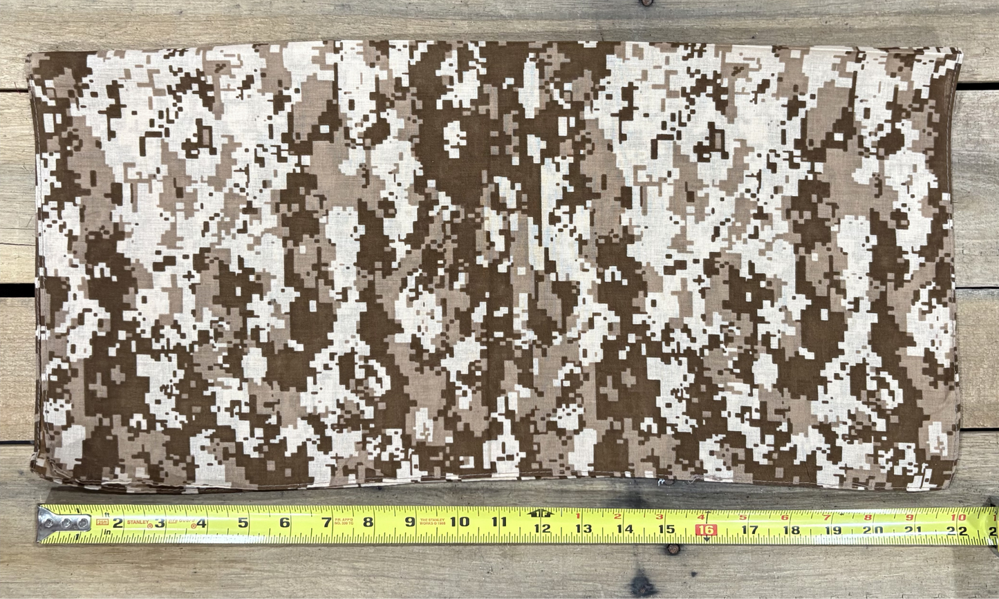 Digital Camo Brown bandana with white paisley patterns on a wooden surface, measured by a yellow tape measure.