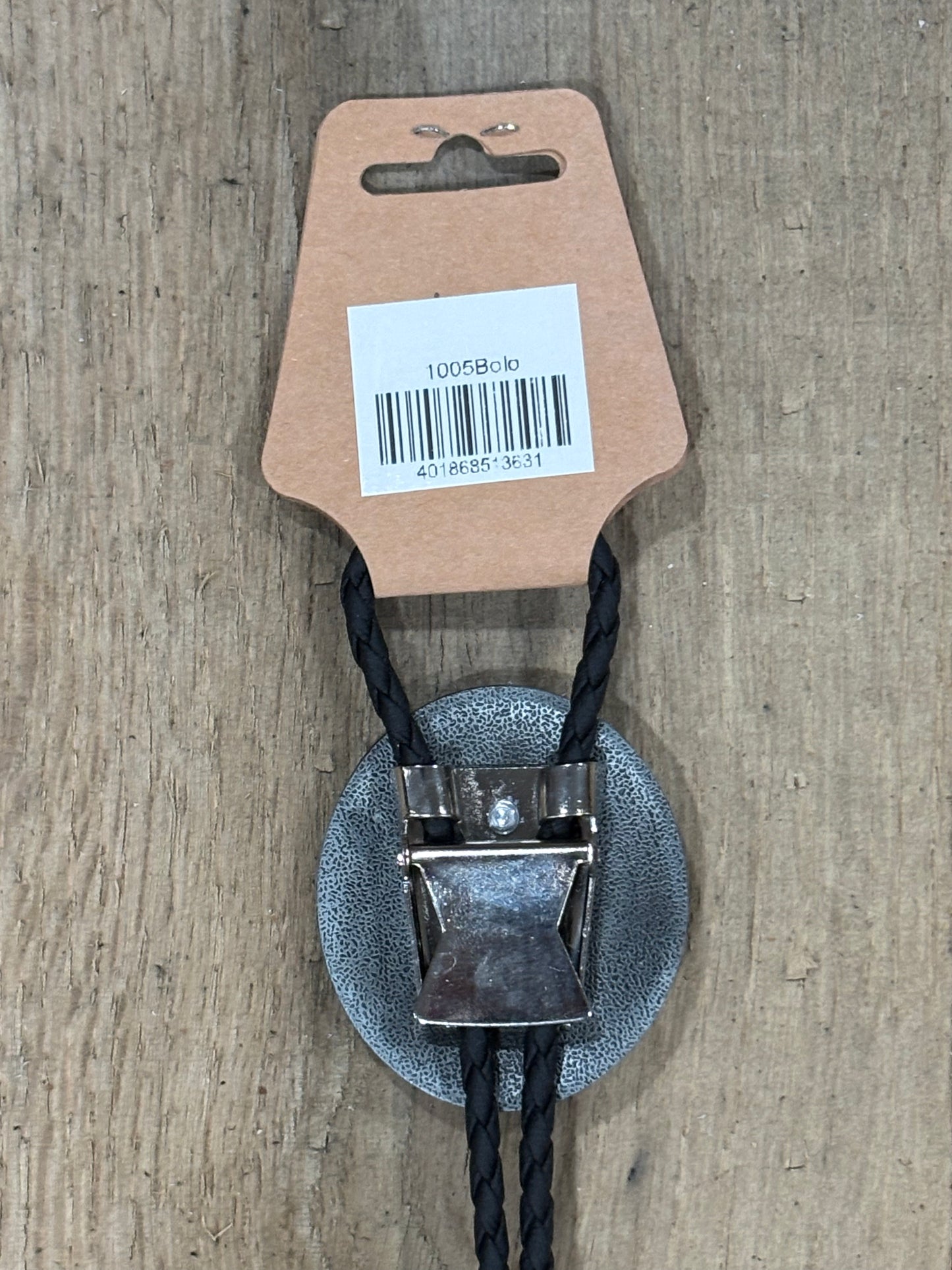 Metal clip with black cord on a cardboard backing with a barcode on a wooden surface