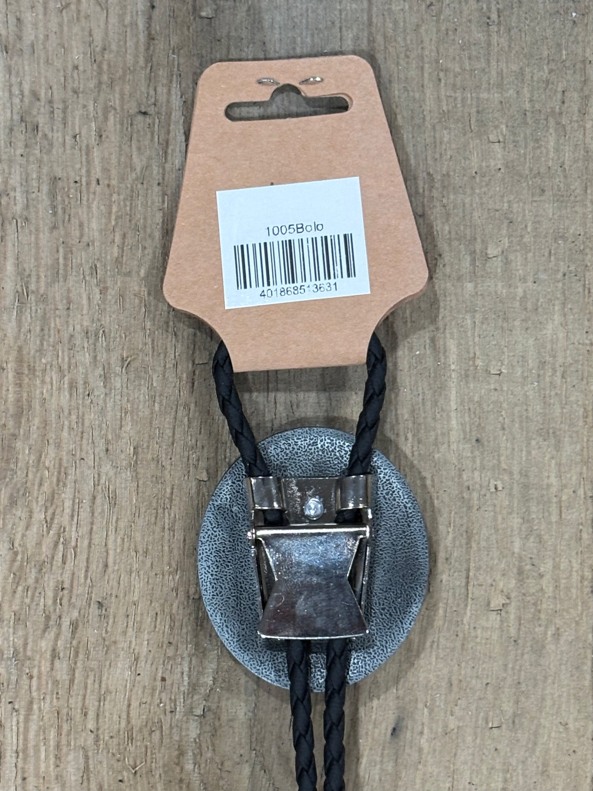 Metal clip with black cord on a cardboard backing with a barcode on a wooden surface