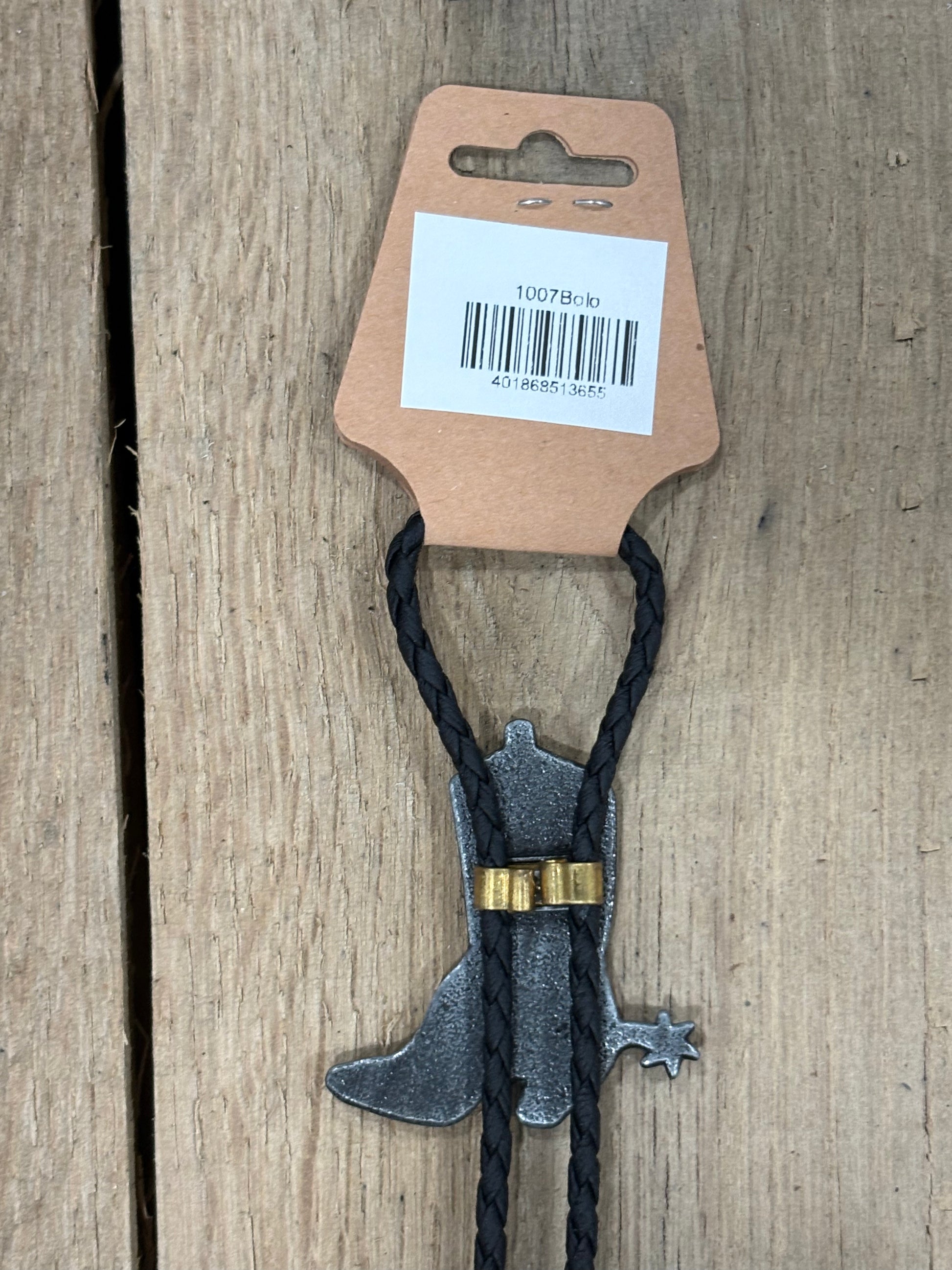Metal clip with black cord on a cardboard backing with a barcode on a wooden surface