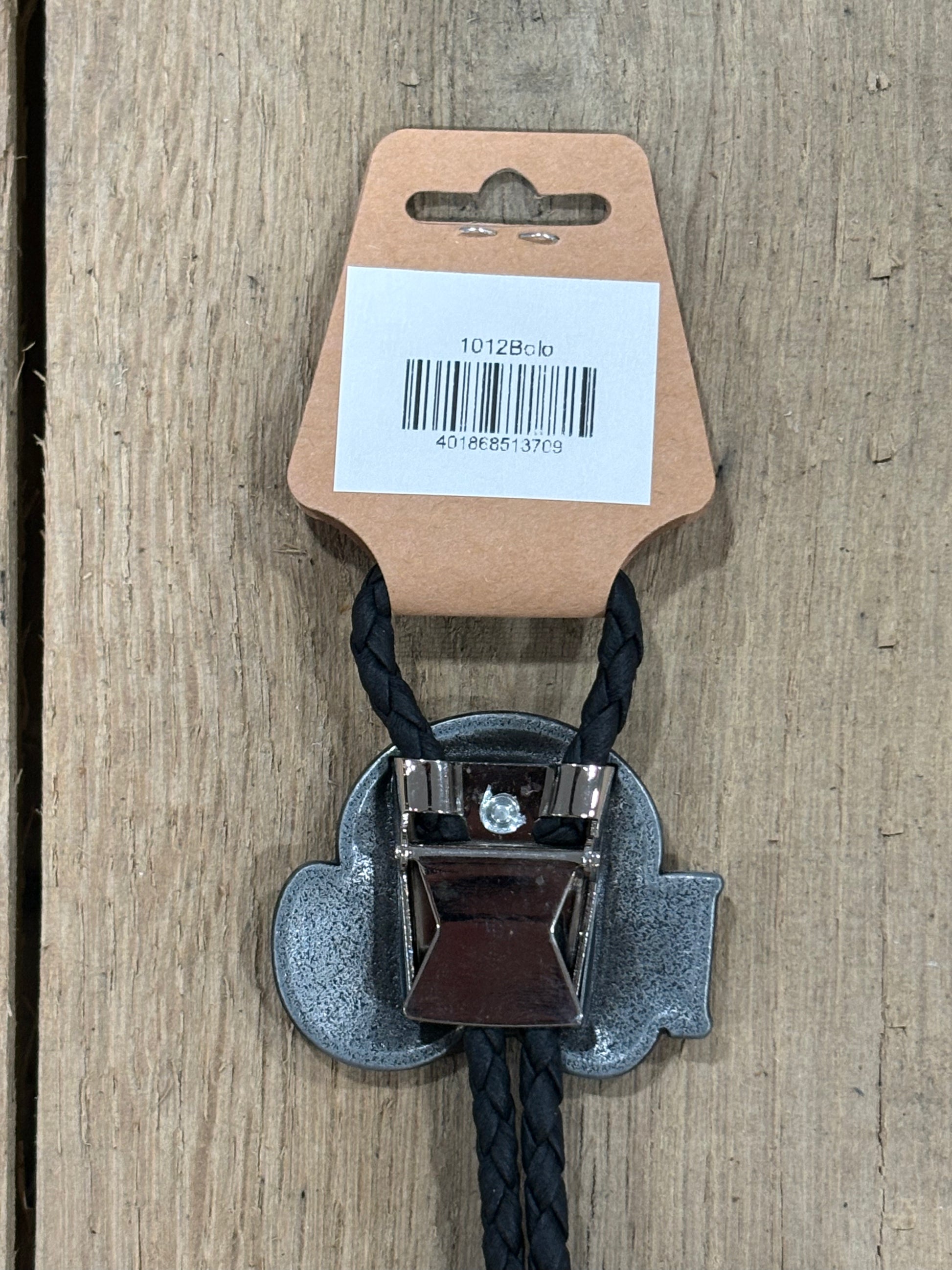 Metal clip with black cord on a cardboard backing with a barcode on a wooden surface