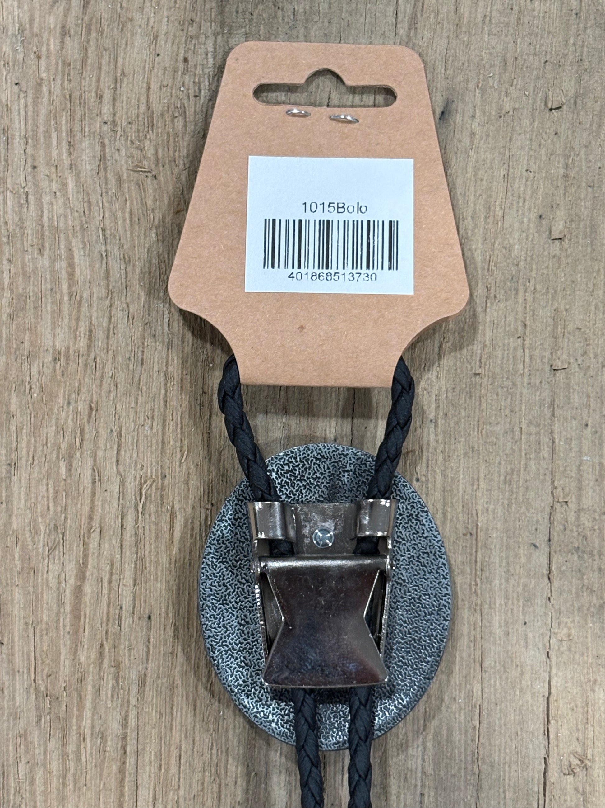 Metal clip with black cord on a cardboard backing with a barcode on a wooden surface