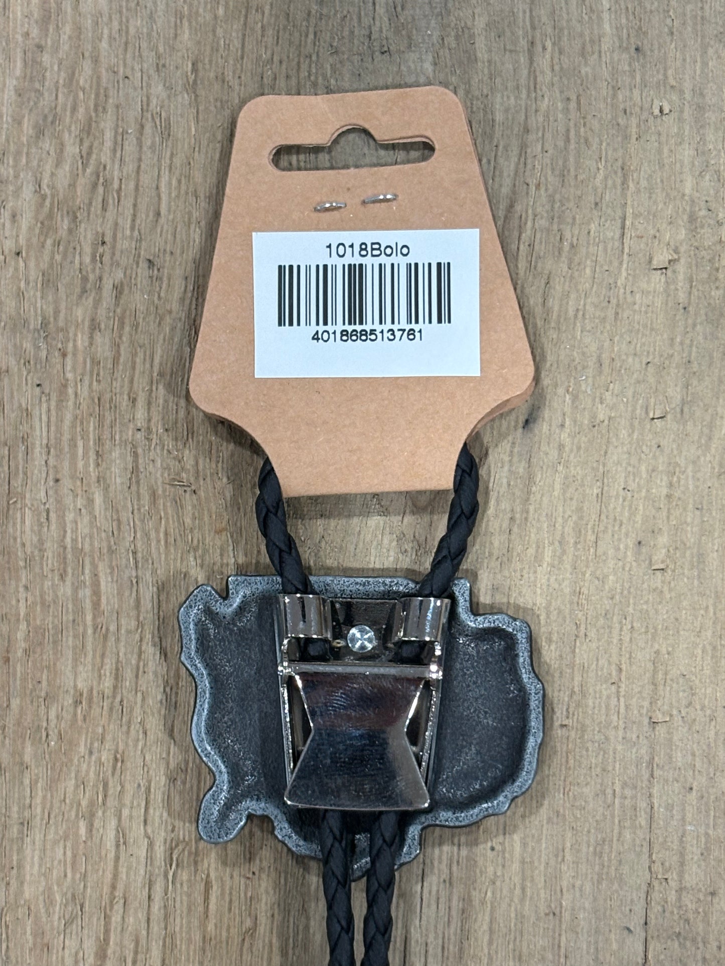 Metal clip with black cord on a cardboard backing with a barcode on a wooden surface
