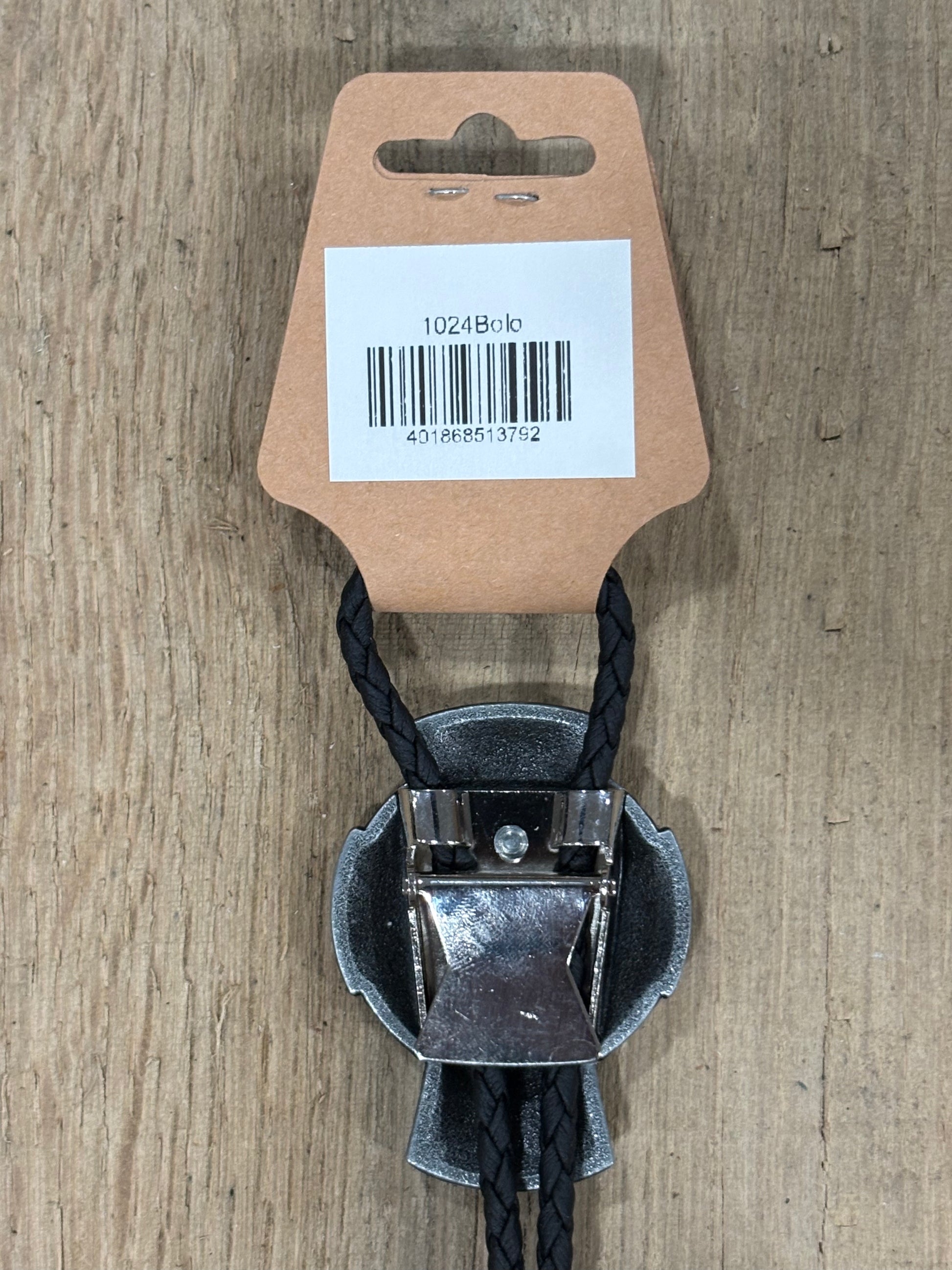 Metal clip with black cord on a cardboard backing with a barcode on a wooden surface