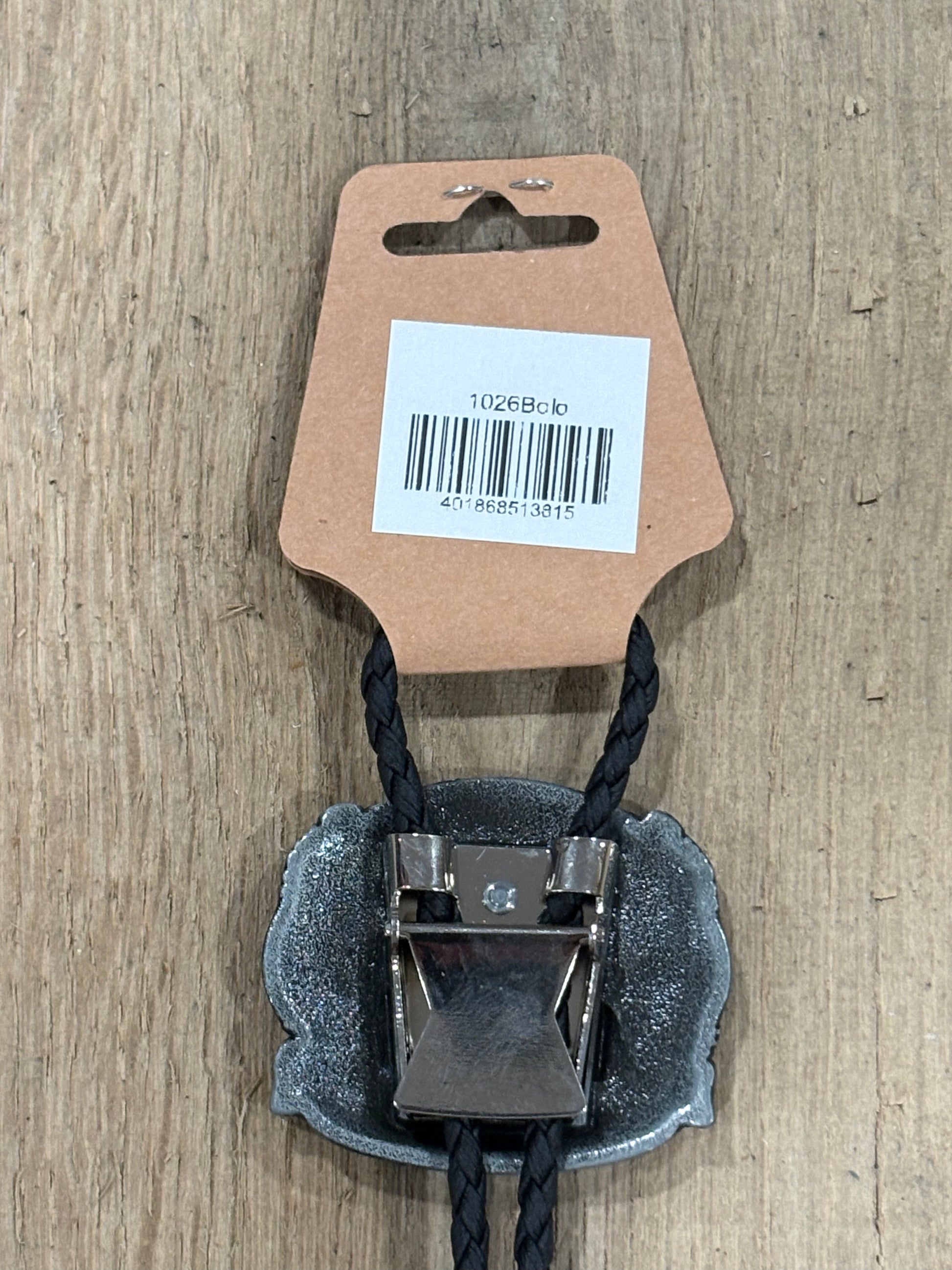 Metal clip with black cord on a cardboard backing with a barcode on a wooden surface