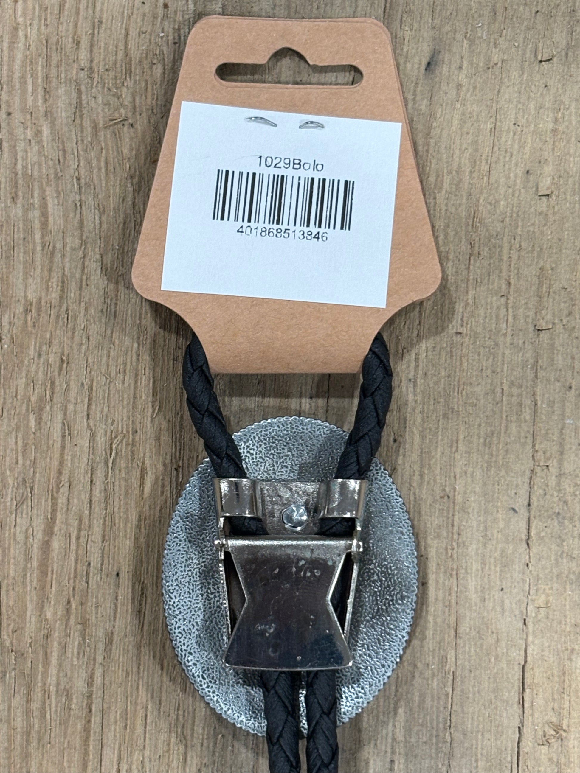 Metal clip with black cord on a cardboard backing with a barcode on a wooden surface
