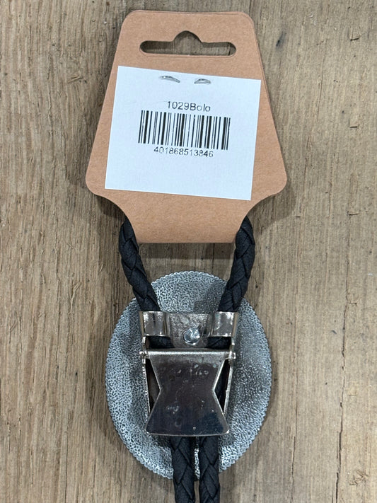 Metal clip with black cord on a cardboard backing with a barcode on a wooden surface