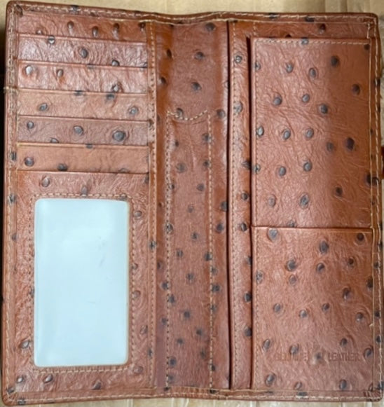 Brown leather wallet with embossed texture on a beige background