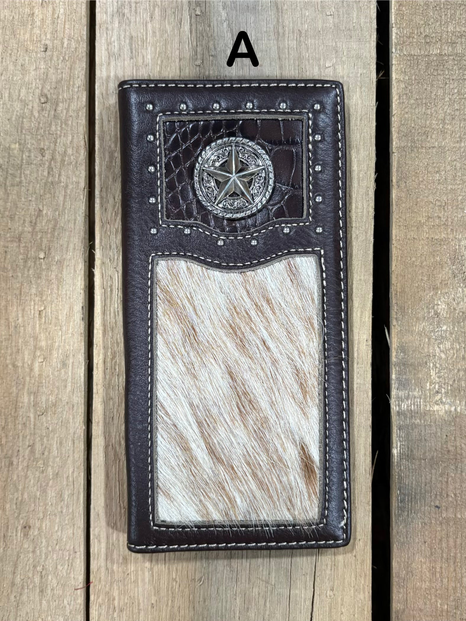 Coffee brown leather wallet with star concho design on a wooden surface