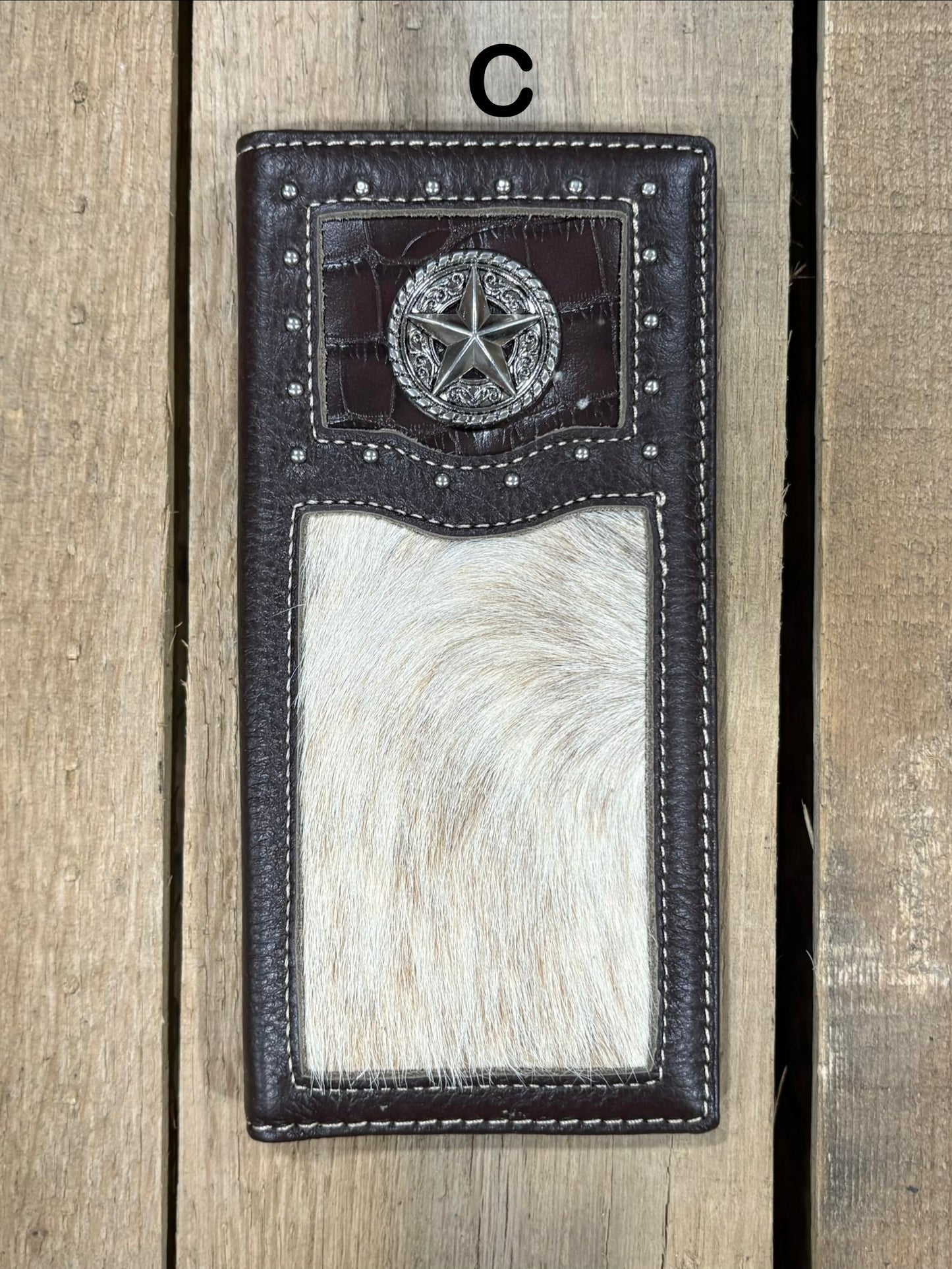 Coffee brown leather wallet with star concho design on a wooden surface