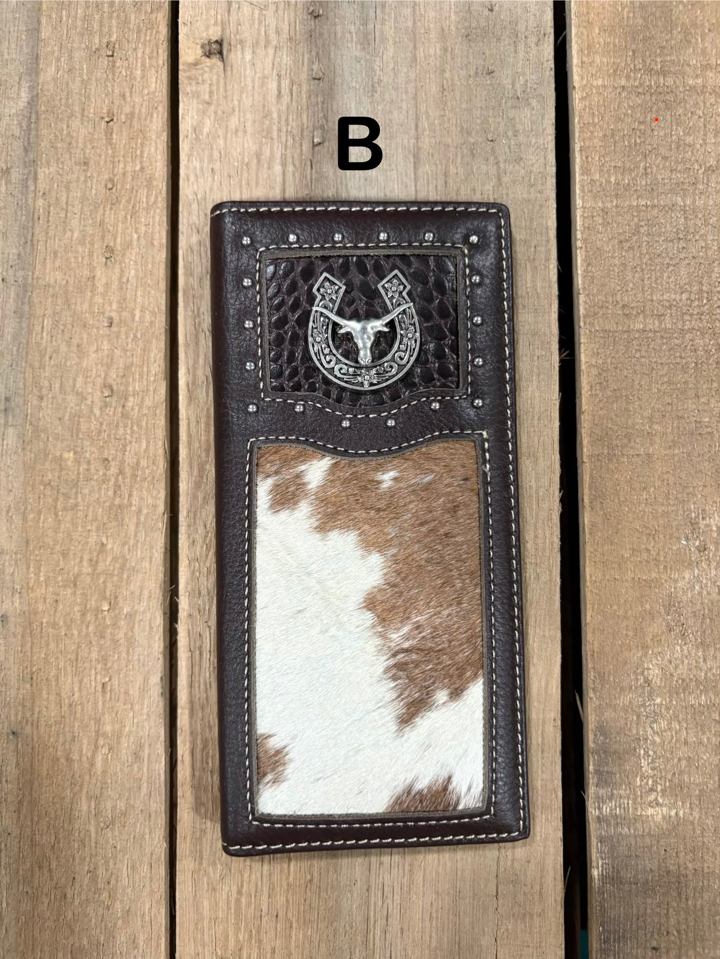 Coffee brown leather wallet with horseshoe and longhorn concho design on a wooden surface