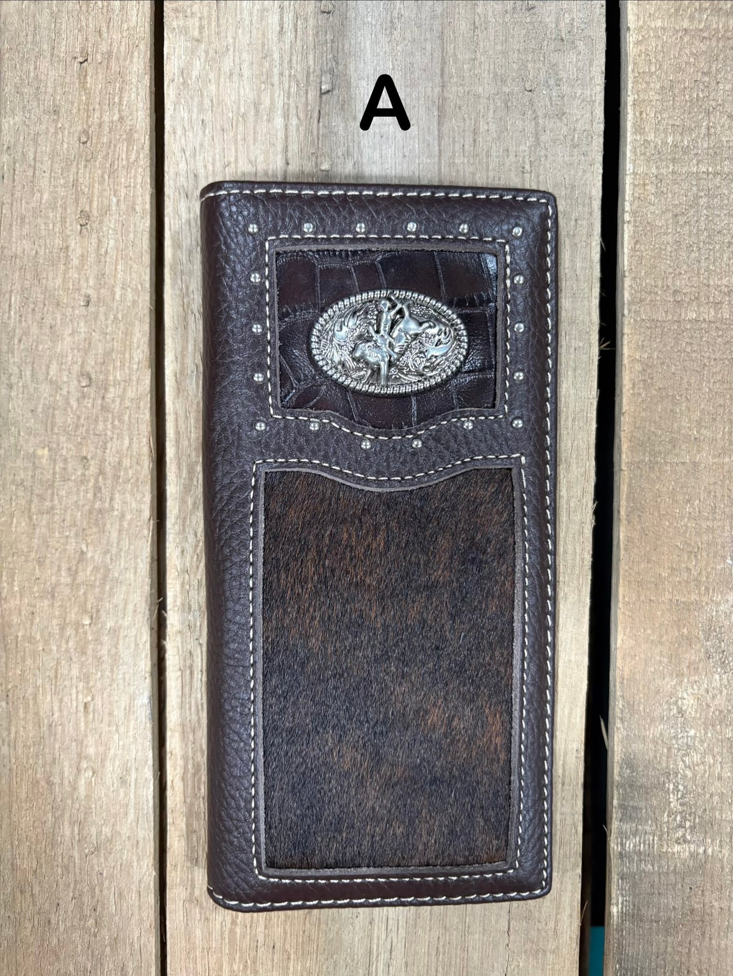 Coffee brown leather wallet with bull rider concho design on a wooden surface