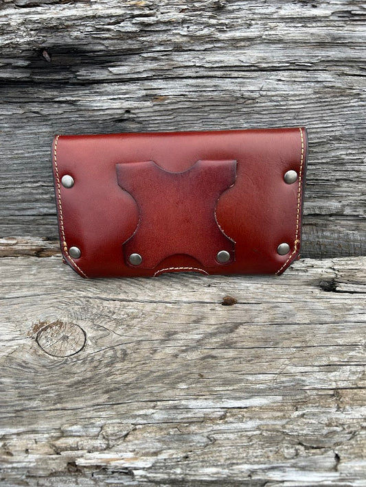 Brown leather phone case with a embossed Praying Cowboy design. It has a smooth leather top, back, and a basketweave leather bottom. Rear view showing leather belt loop attachments.