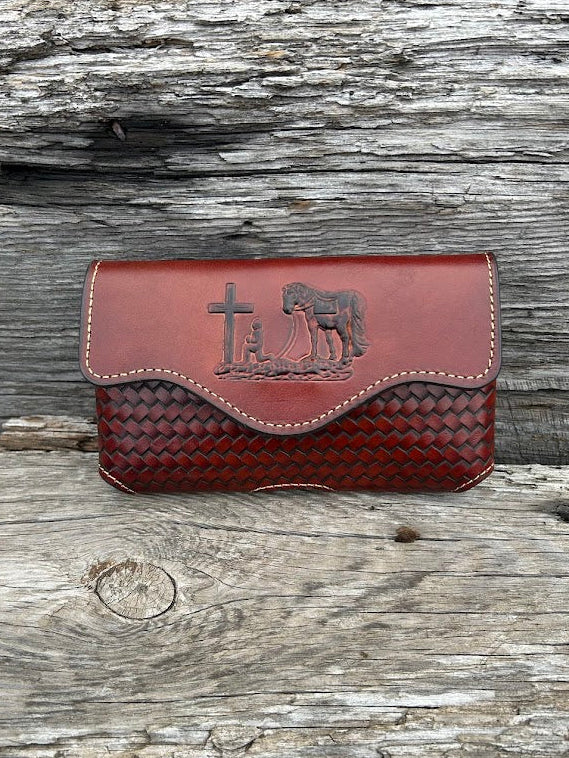 Brown leather phone case with a embossed Praying Cowboy design. It has a smooth leather top, back, and a basketweave leather bottom. Front View
