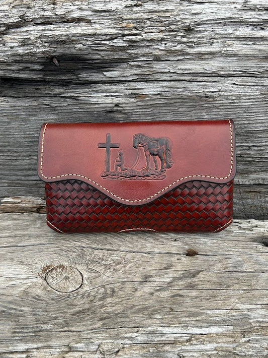 Brown leather phone case with a embossed Praying Cowboy design. It has a smooth leather top, back, and a basketweave leather bottom. Front View