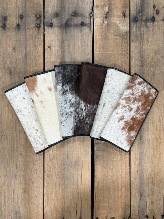 Six cowhide leather wallets on a wooden surface