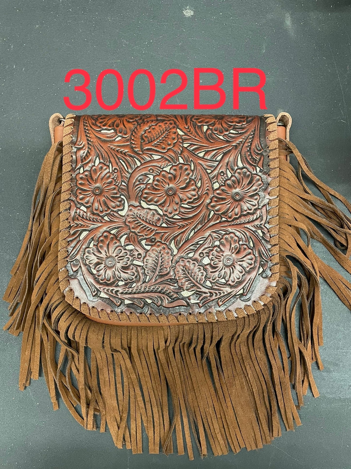 Brown leather bag with intricate patterns and fringes on a gray background, labeled '3002BR'.