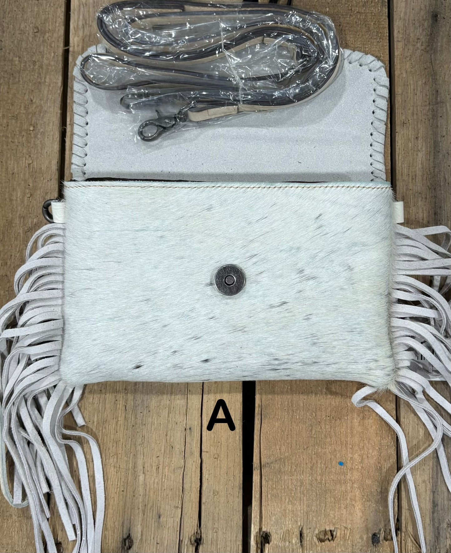 White tooled leather and cowhide bag with side fringe. This bag has both a wristlet and should strap. Front View