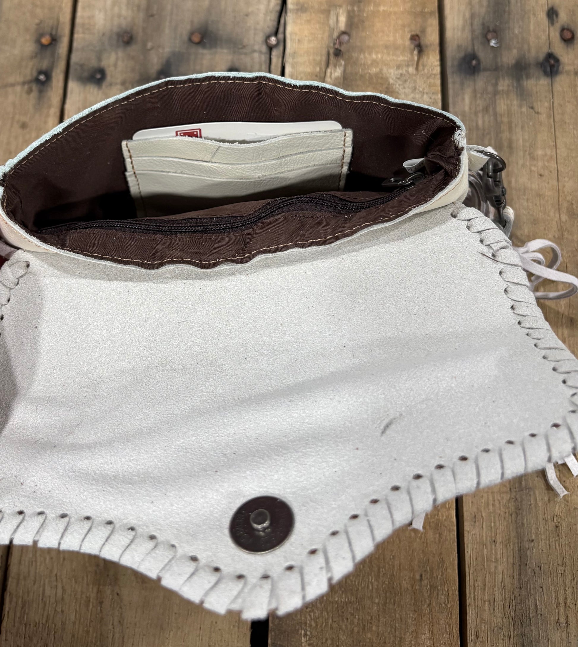 Card slot view of a beige cowhide crossbody purse.