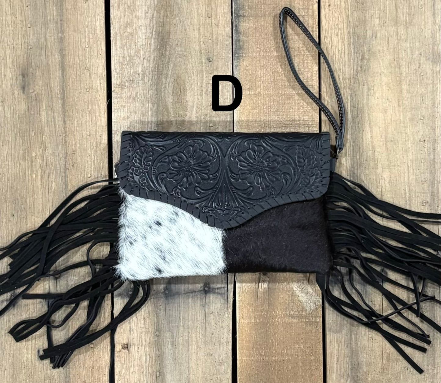 Black tooled leather and cowhide bag with side fringe. This bag has both a wristlet and should strap. Front View