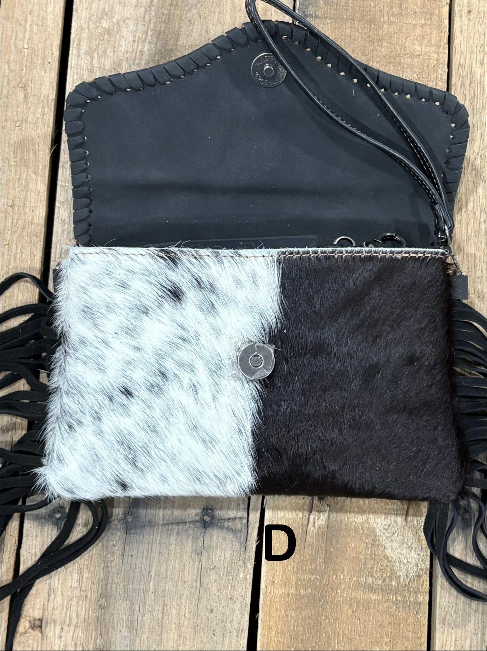 Black tooled leather and cowhide bag with side fringe. This bag has both a wristlet and should strap. Front View