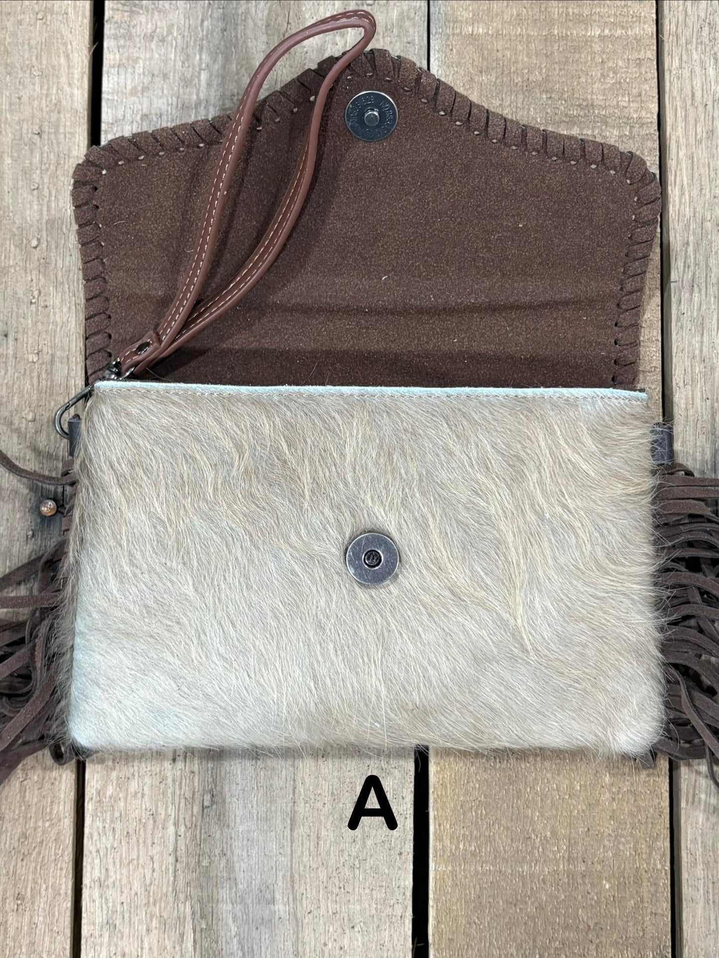 Coffee Brown tooled leather and cowhide bag with side fringe. This bag has both a wristlet and should strap. Front View