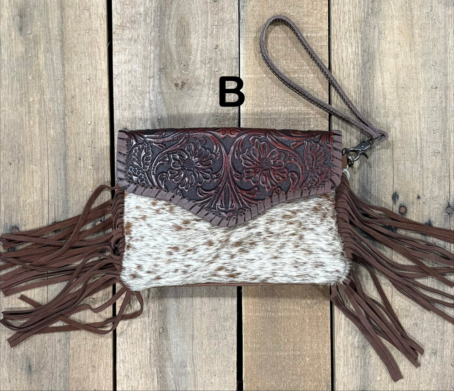 Coffee Brown tooled leather and cowhide bag with side fringe. This bag has both a wristlet and should strap. Front View