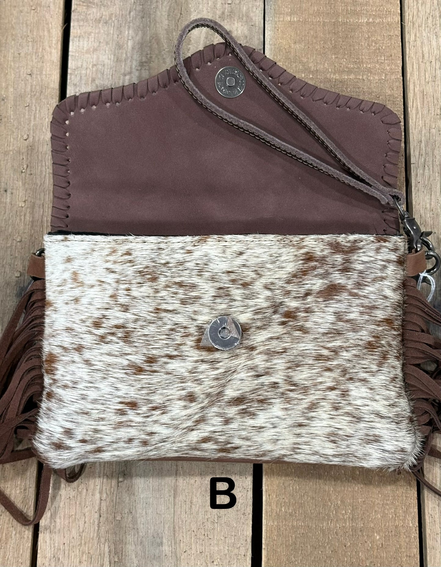 Coffee Brown tooled leather and cowhide bag with side fringe. This bag has both a wristlet and should strap. Front View