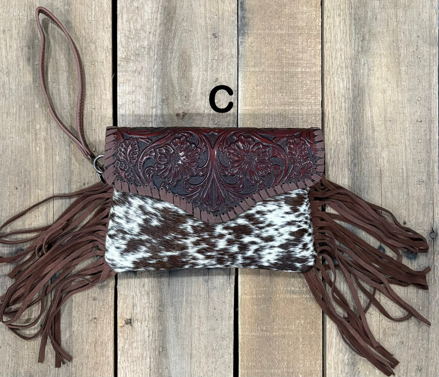 Coffee Brown tooled leather and cowhide bag with side fringe. This bag has both a wristlet and should strap. Front View