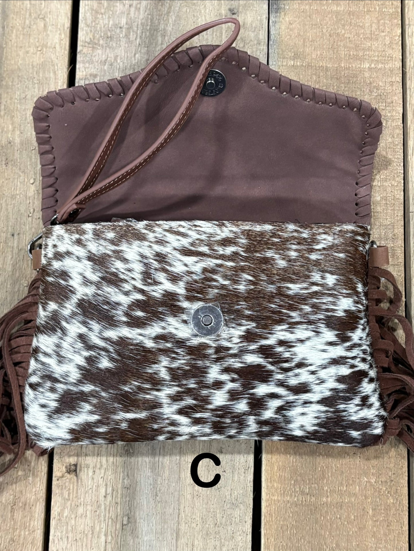 Coffee Brown tooled leather and cowhide bag with side fringe. This bag has both a wristlet and should strap. Front View