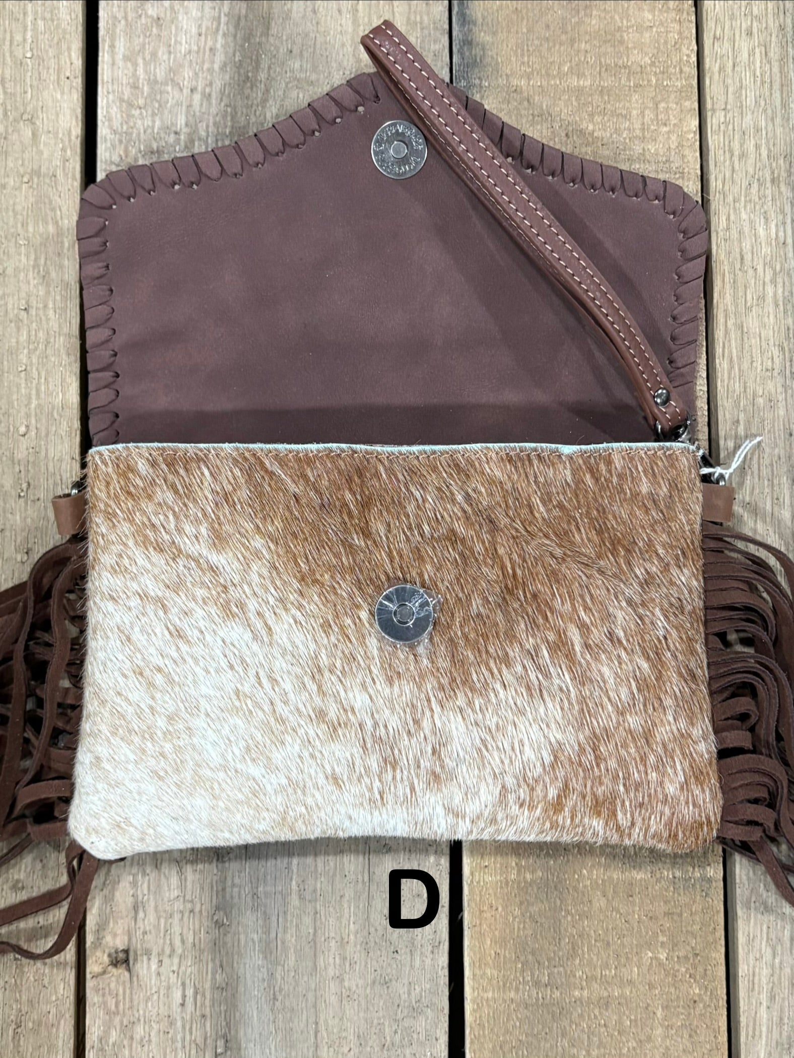 Coffee Brown tooled leather and cowhide bag with side fringe. This bag has both a wristlet and should strap. Front View