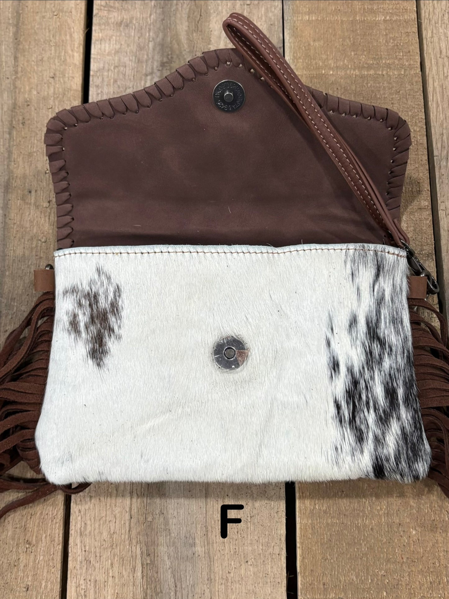 Coffee Brown tooled leather and cowhide bag with side fringe. This bag has both a wristlet and should strap. Front View