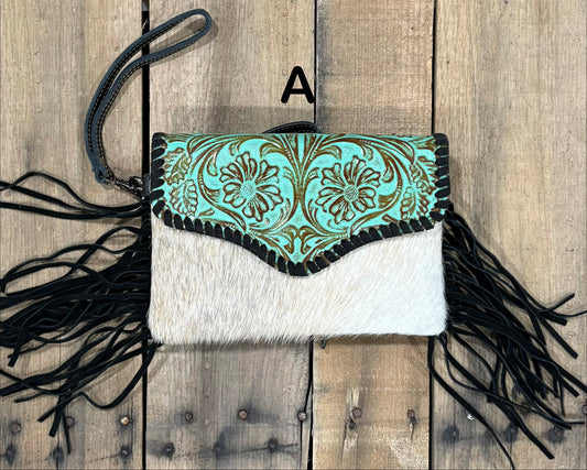 Turquoise tooled leather and cowhide bag with side fringe. This bag has both a wristlet and should strap. Front View