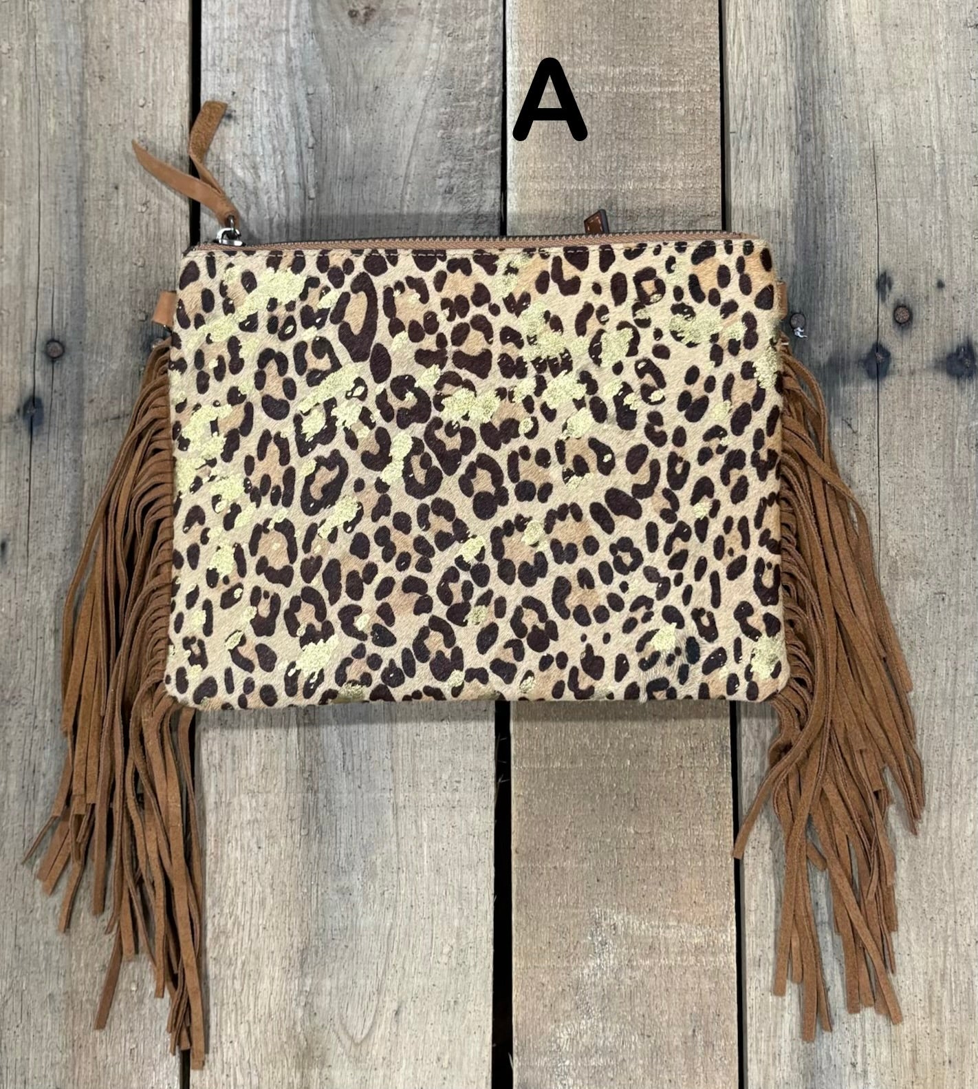 Brown Leopard crossbody bag with fringe on a wooden background