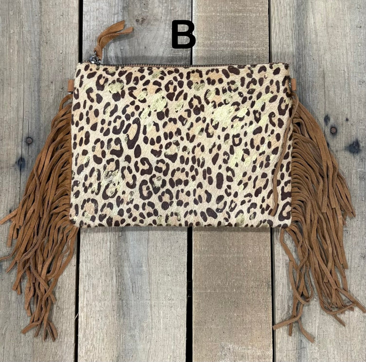 Brown Leopard crossbody bag with fringe on a wooden background