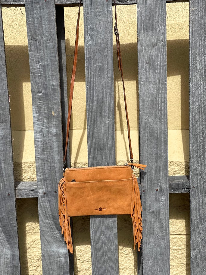 This Leopard print cowhide bag features Brown leather fringe sides and zips close. It has a removable adjustable shoulder strap and a rear pocket that also zips closed. Rear view showing zippered closed pocket. 