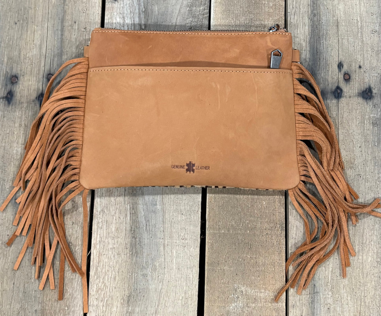 Brown Leopard crossbody bag with fringe on a wooden background