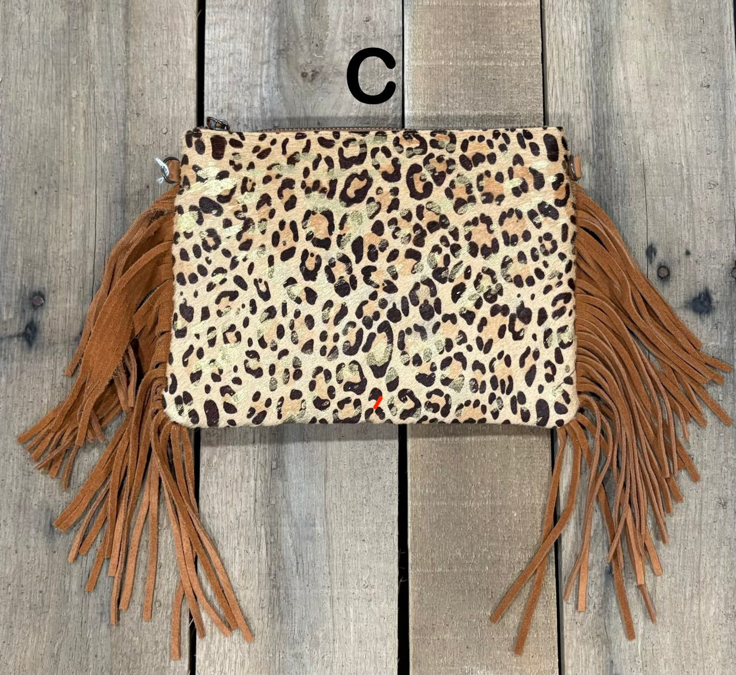 Brown Leopard crossbody bag with fringe on a wooden background