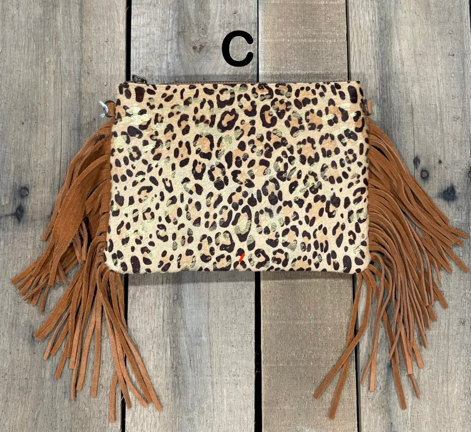 Brown Leopard crossbody bag with fringe on a wooden background
