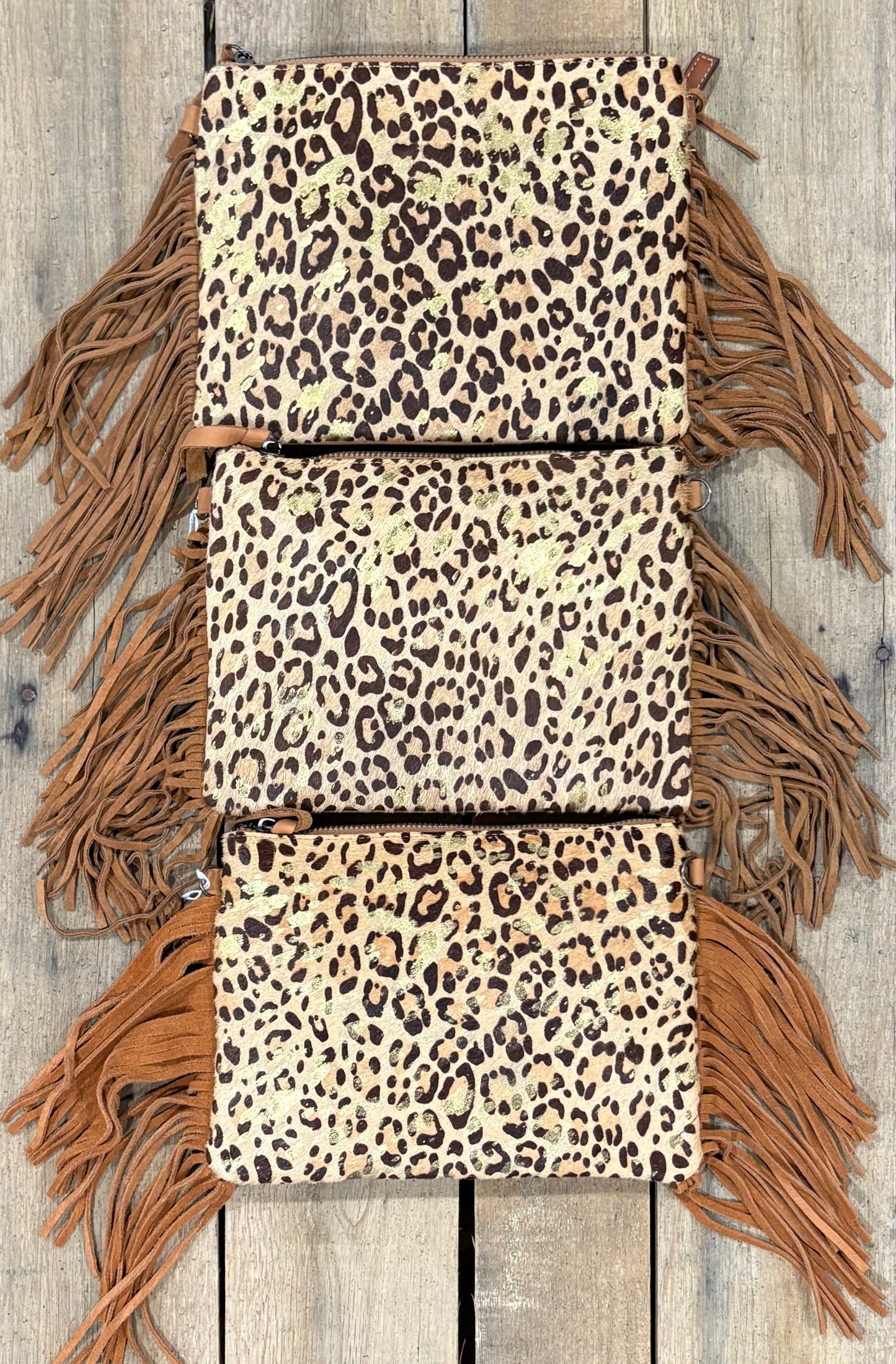 Three purse view of leopard crossbodys on a wooden background