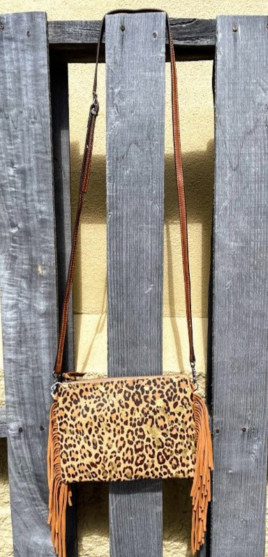 This Leopard print cowhide bag features Brown leather fringe sides and zips close. It has a removable adjustable shoulder strap and a rear pocket that also zips closed. Front View