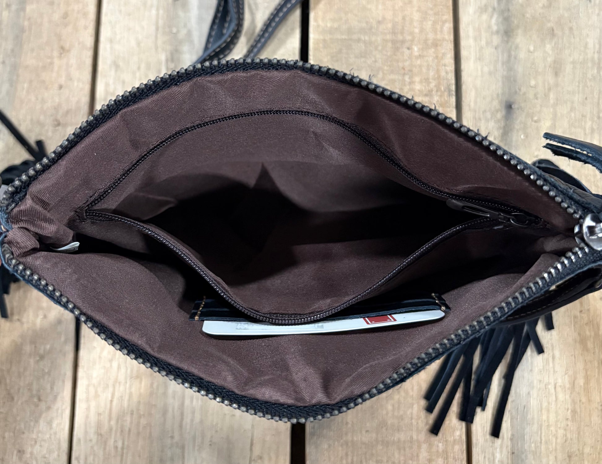 Inside Zipper view of a black leather crossbody purse.