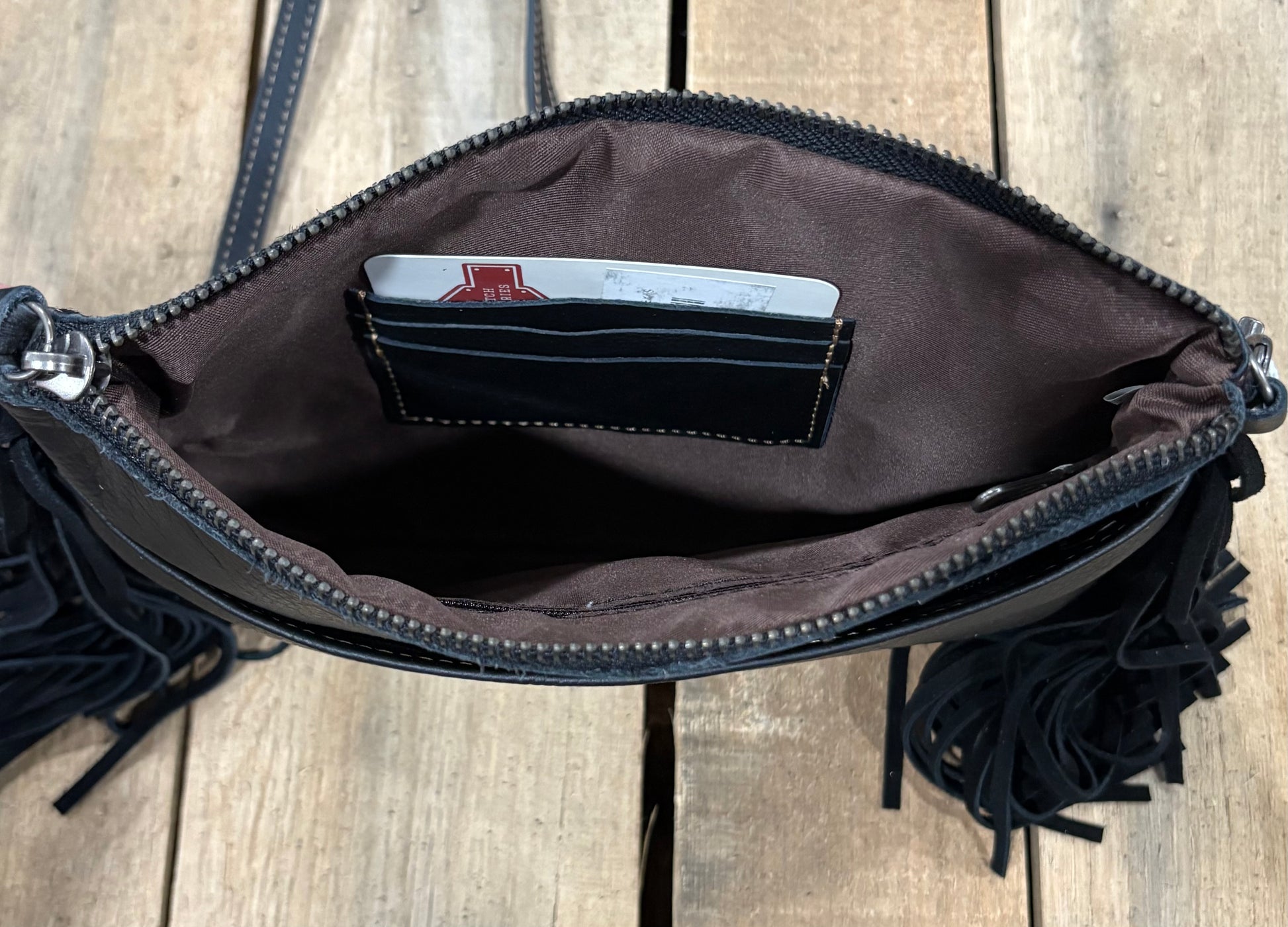 Card slot view of a black cowhide crossbody purse.